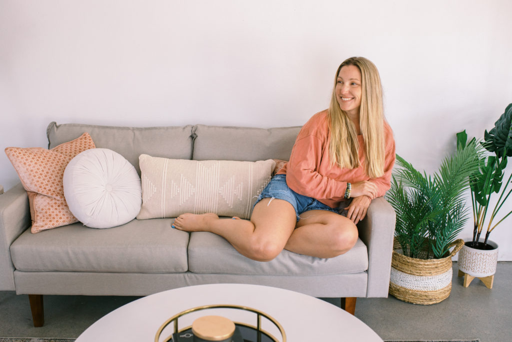 a photography business coach sitting on a cozy sofa for her branding photos